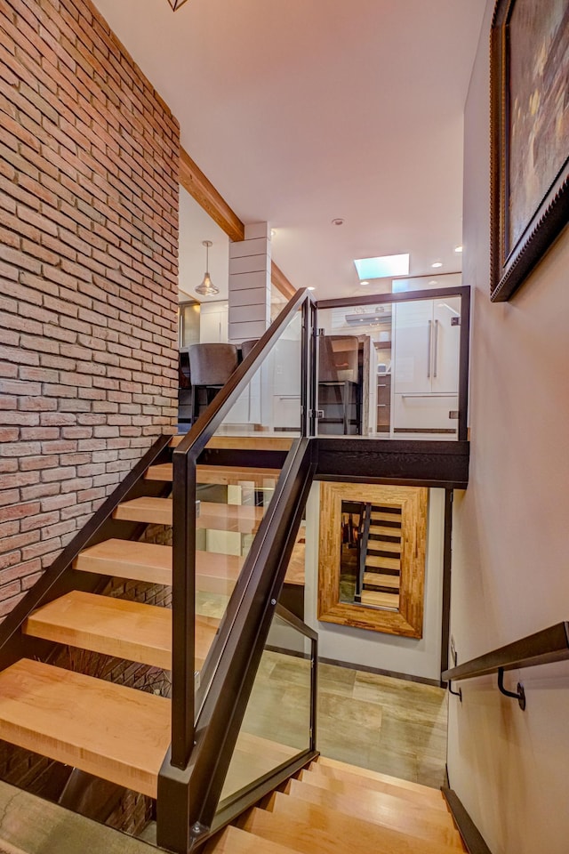120 Eastbank Ct N, North Hudson, WI 54016 - stairway featuring brick wall and wood finished floors