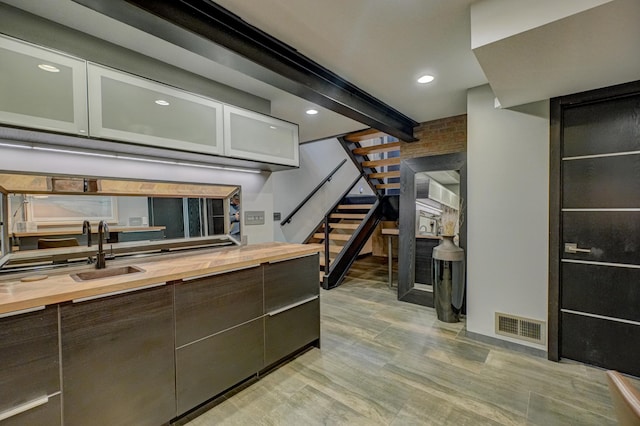 120 Eastbank Ct N, North Hudson, WI 54016 - kitchen with wooden counters, a sink, glass insert cabinets, and recessed lighting