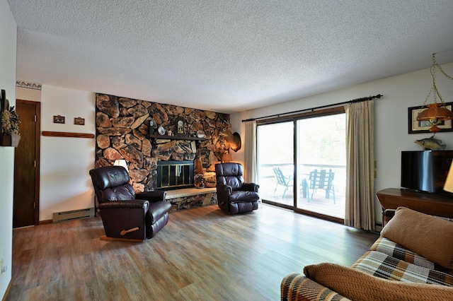 W2847 County Highway B, Madge Twp, WI 54870 - living room featuring a textured ceiling, baseboard heating, wood finished floors, and a stone fireplace