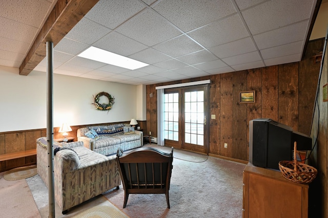 W2847 County Highway B, Madge Twp, WI 54870 - carpeted living area featuring wood walls, a paneled ceiling, and a baseboard radiator