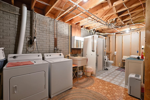 W2847 County Highway B, Madge Twp, WI 54870 - laundry room featuring washing machine and clothes dryer, light flooring, and brick wall
