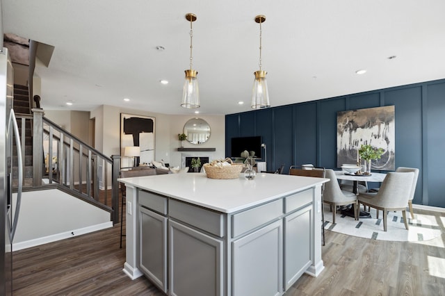 10383 Glacier Ln N, Maple Grove, MN 55369 - kitchen with a fireplace, dark wood-style flooring, pendant lighting, light countertops, and a decorative wall