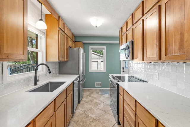 4342 Arthur St NE, Columbia Heights, MN 55421 - kitchen with appliances with stainless steel finishes, a sink, baseboards, tasteful backsplash, and a textured ceiling