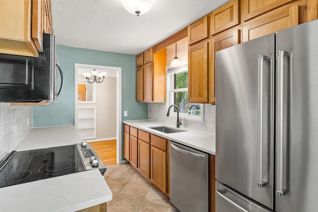 4342 Arthur St NE, Columbia Heights, MN 55421 - kitchen with appliances with stainless steel finishes, a sink, tasteful backsplash, a chandelier, and brown cabinetry
