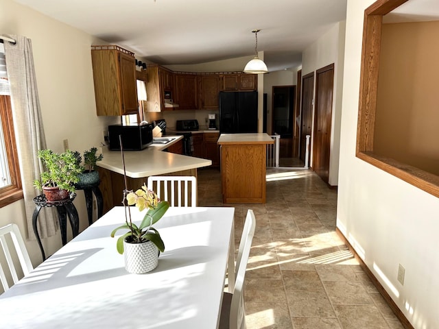 103 8th St SW, Roseau, MN 56751 - kitchen with black appliances, light countertops, baseboards, decorative light fixtures, and a center island
