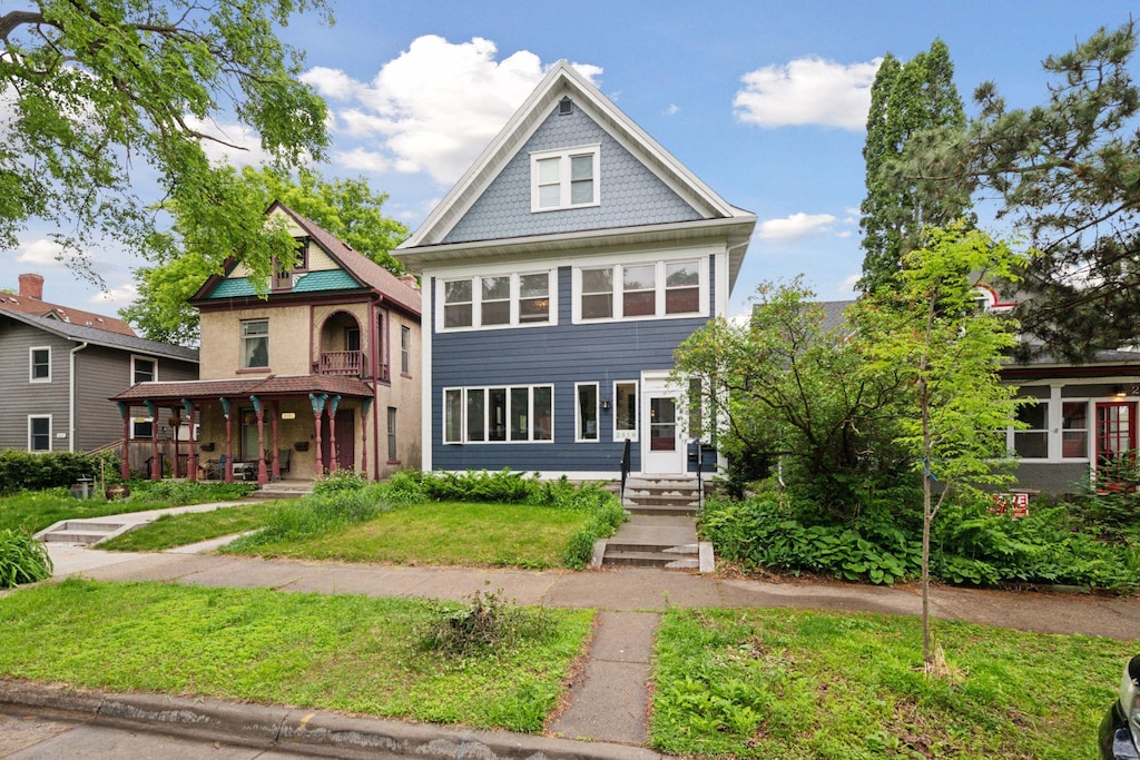 2519 22nd St, Minneapolis, MN 55406 - victorian-style house featuring a porch, a front lawn, and a balcony
