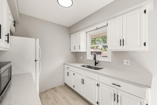 825 Elm Creek Cir, Champlin, MN 55316 - kitchen featuring a sink, stainless steel microwave, white cabinetry, light wood finished floors, and light stone counters