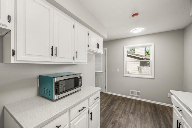 825 Elm Creek Cir, Champlin, MN 55316 - kitchen featuring stainless steel microwave, dark wood-type flooring, white cabinetry, baseboards, and light stone counters