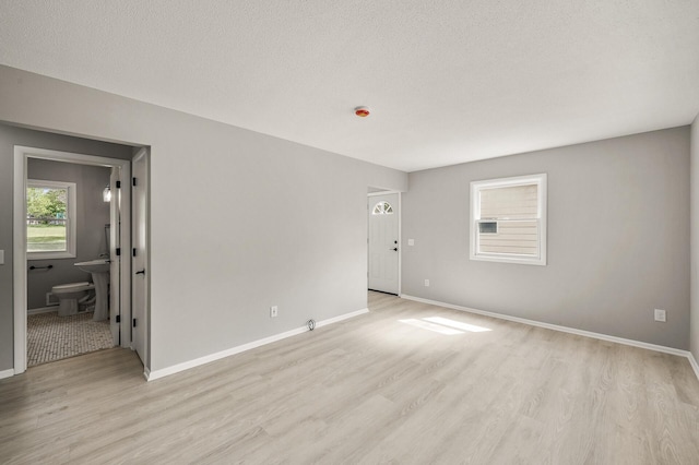 825 Elm Creek Cir, Champlin, MN 55316 - spare room with light wood finished floors, baseboards, and a textured ceiling