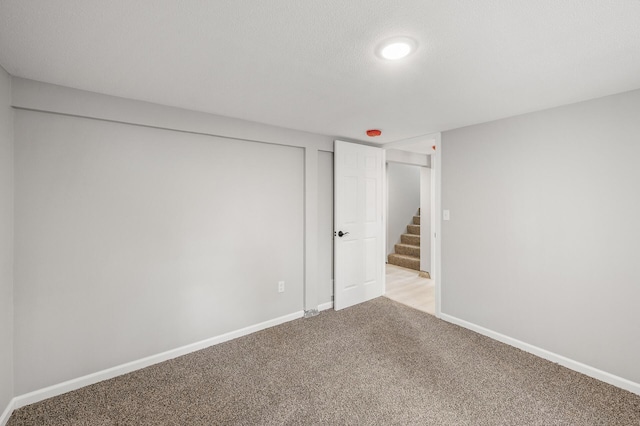 825 Elm Creek Cir, Champlin, MN 55316 - unfurnished room featuring light colored carpet, stairway, and baseboards