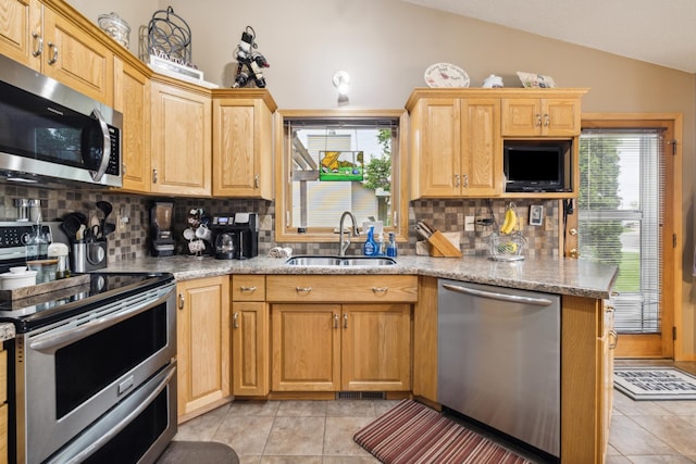 2031 Rose Creek Dr S, Fargo, ND 58104 - kitchen featuring stainless steel appliances, a sink, lofted ceiling, tasteful backsplash, and light tile patterned floors