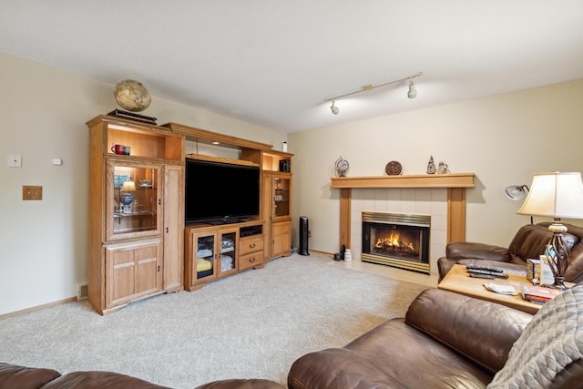 2031 Rose Creek Dr S, Fargo, ND 58104 - living area featuring light colored carpet, a tiled fireplace, and track lighting