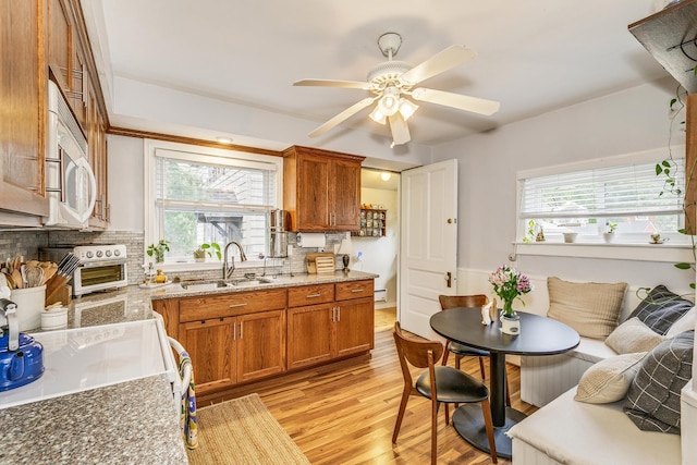 1491 Wynne Ave, Saint Paul, MN 55108 - kitchen with a sink, healthy amount of natural light, decorative backsplash, and brown cabinetry