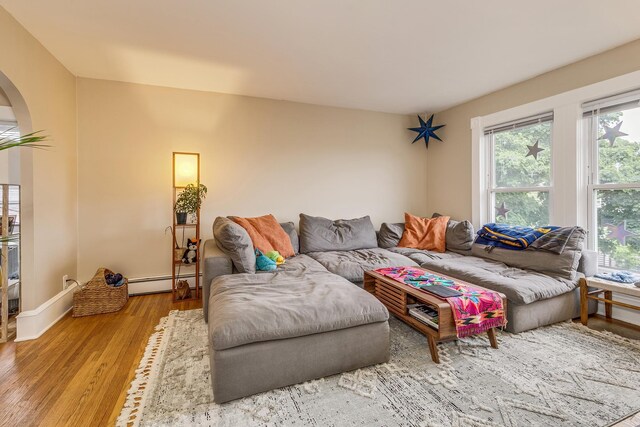1491 Wynne Ave, Saint Paul, MN 55108 - living room with a baseboard radiator, arched walkways, wood finished floors, and baseboards