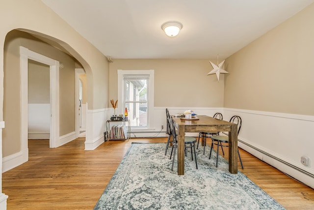 1491 Wynne Ave, Saint Paul, MN 55108 - dining area with a baseboard radiator, arched walkways, and wood finished floors