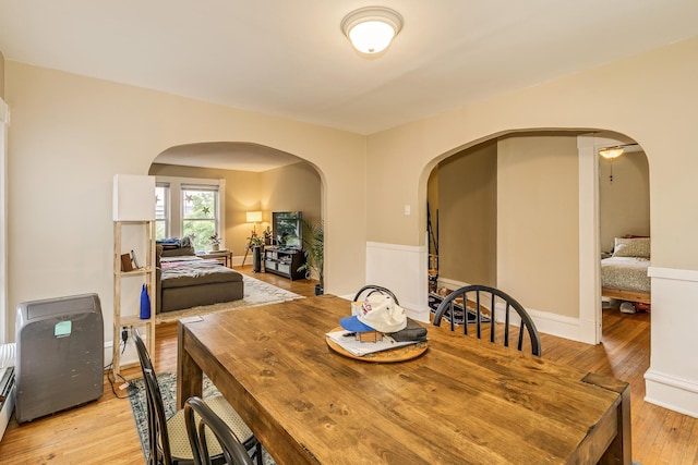 1491 Wynne Ave, Saint Paul, MN 55108 - dining area with arched walkways, light wood-type flooring, baseboard heating, and baseboards