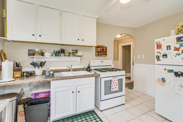 1491 Wynne Ave, Saint Paul, MN 55108 - kitchen featuring white appliances, arched walkways, white cabinetry, and a sink