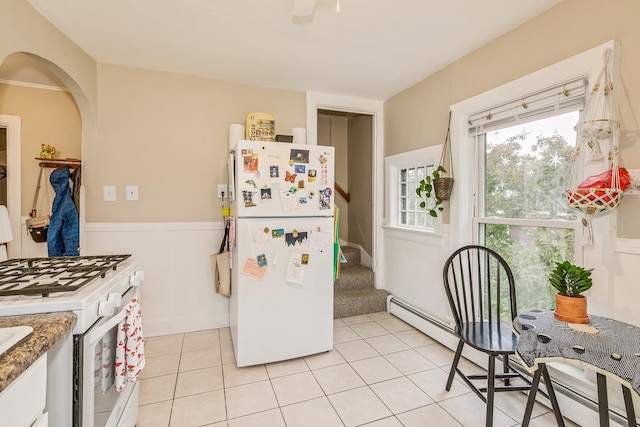 1491 Wynne Ave, Saint Paul, MN 55108 - kitchen featuring white appliances, light tile patterned flooring, white cabinets, arched walkways, and a baseboard heating unit