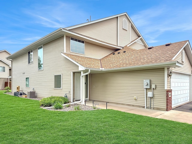 10809 Tyler Ct NE, Blaine, MN 55434 - rear view of property with central air condition unit, roof with shingles, a lawn, and an attached garage