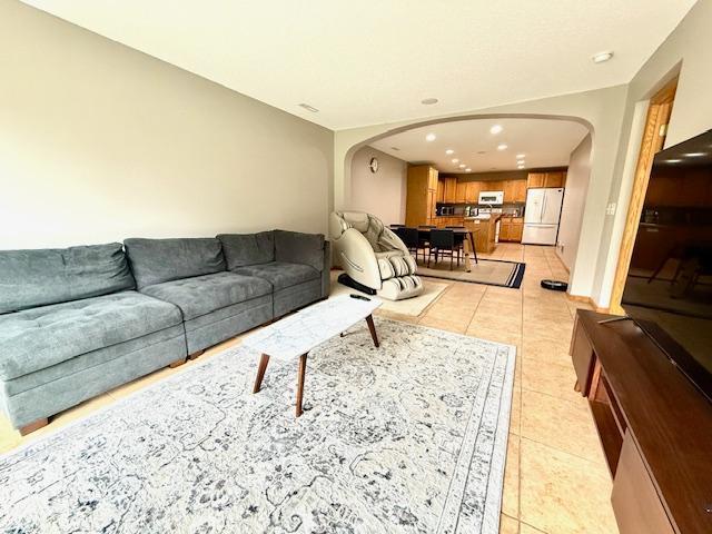 10809 Tyler Ct NE, Blaine, MN 55434 - living room featuring arched walkways, recessed lighting, and light tile patterned flooring