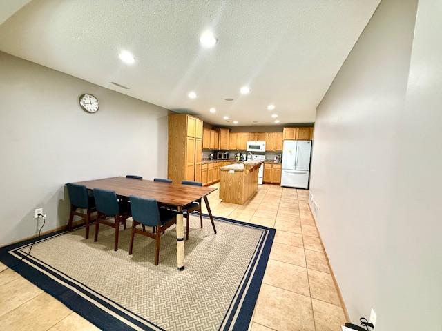 10809 Tyler Ct NE, Blaine, MN 55434 - dining area featuring recessed lighting, light tile patterned floors, a textured ceiling, and baseboards