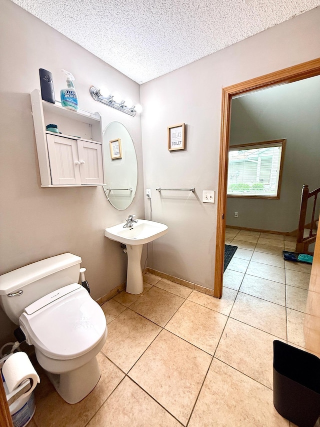 10809 Tyler Ct NE, Blaine, MN 55434 - bathroom featuring tile patterned flooring, a textured ceiling, toilet, and baseboards