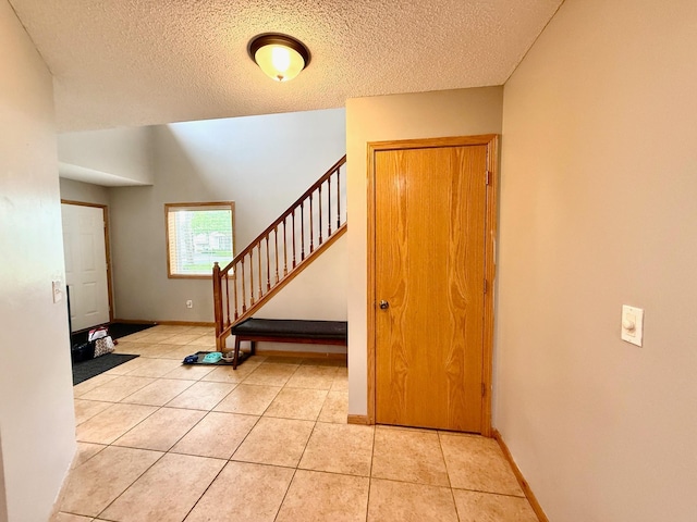 10809 Tyler Ct NE, Blaine, MN 55434 - entrance foyer with light tile patterned floors, stairway, a textured ceiling, and baseboards
