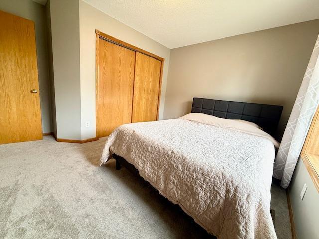 10809 Tyler Ct NE, Blaine, MN 55434 - carpeted bedroom featuring a closet and baseboards