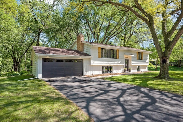 18120 27th Ave N, Plymouth, MN 55447 - split foyer home featuring a chimney, a garage, driveway, and a front yard