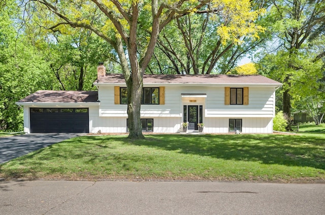18120 27th Ave N, Plymouth, MN 55447 - raised ranch featuring a chimney, asphalt driveway, an attached garage, and a front yard