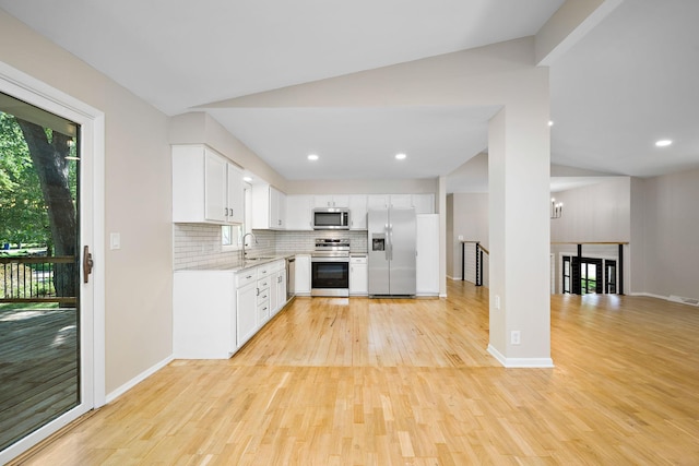 18120 27th Ave N, Plymouth, MN 55447 - kitchen featuring stainless steel appliances, vaulted ceiling, light wood-type flooring, backsplash, and a sink
