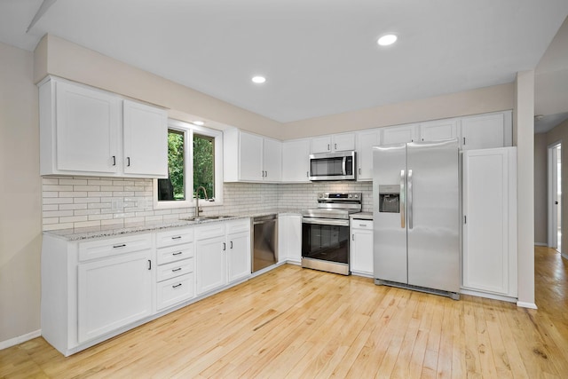 18120 27th Ave N, Plymouth, MN 55447 - kitchen featuring stainless steel appliances, a sink, light wood-style flooring, decorative backsplash, and white cabinets