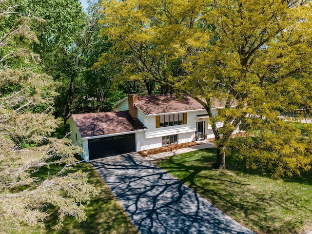 18120 27th Ave N, Plymouth, MN 55447 - tri-level home with an attached garage, concrete driveway, a chimney, a front lawn, and covered porch