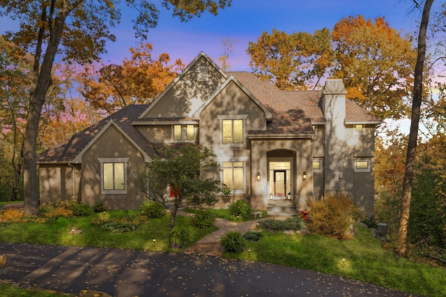 4266 Manor Court Rd, Minnetonka, MN 55345 - traditional-style home featuring a chimney, stucco siding, a lawn, and roof with shingles