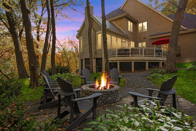 4266 Manor Court Rd, Minnetonka, MN 55345 - rear view of house featuring a fire pit, stucco siding, a standing seam roof, a chimney, and a deck