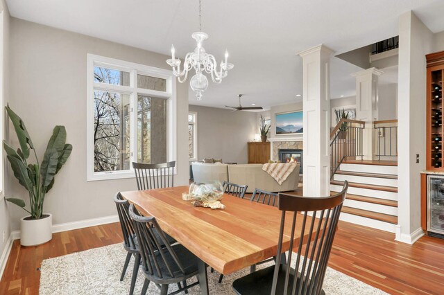 4266 Manor Court Rd, Minnetonka, MN 55345 - dining room with wood finished floors, a premium fireplace, baseboards, a ceiling fan, and stairs
