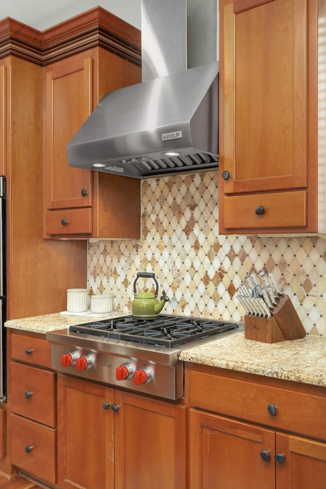 4266 Manor Court Rd, Minnetonka, MN 55345 - kitchen with wall chimney exhaust hood, stainless steel gas stovetop, brown cabinets, and decorative backsplash