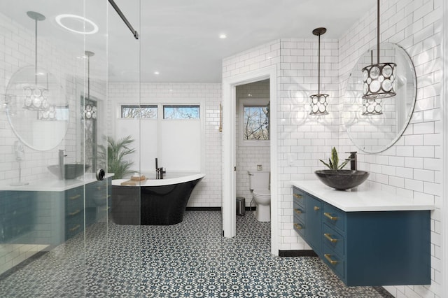 4266 Manor Court Rd, Minnetonka, MN 55345 - bathroom featuring tile walls, vanity, a freestanding tub, a stall shower, and toilet