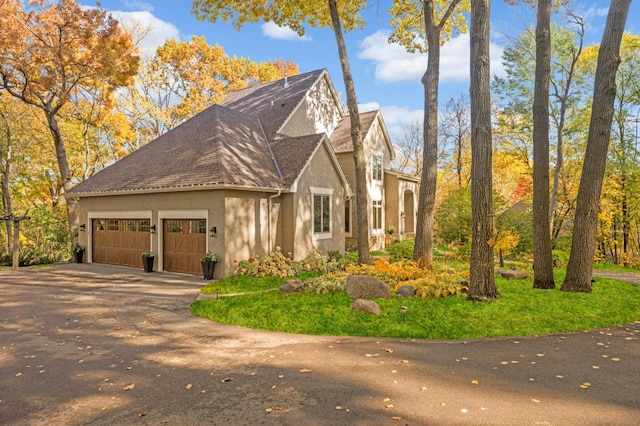 4266 Manor Court Rd, Minnetonka, MN 55345 - view of front facade featuring stucco siding, an attached garage, concrete driveway, and roof with shingles