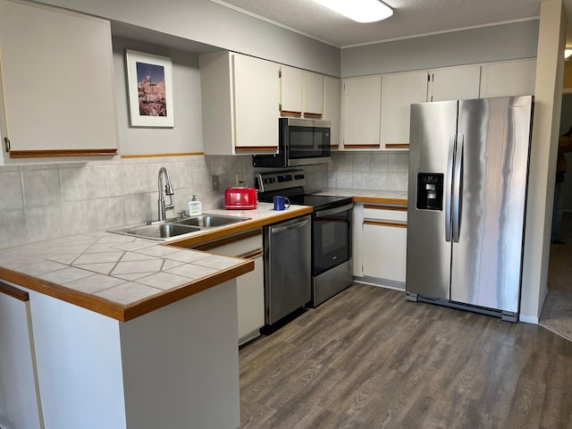 12232 Oak Leaf Cir, Burnsville, MN 55337 - kitchen with appliances with stainless steel finishes, a sink, tile counters, dark wood-style flooring, and white cabinetry