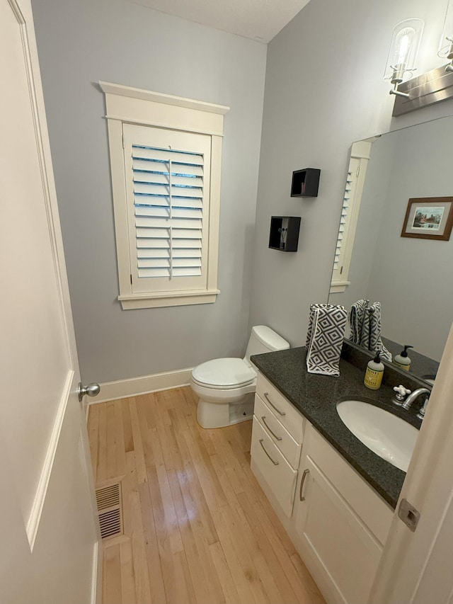 4312 France Ave S, Edina, MN 55410 - bathroom with wood-type flooring, toilet, vanity, and baseboards
