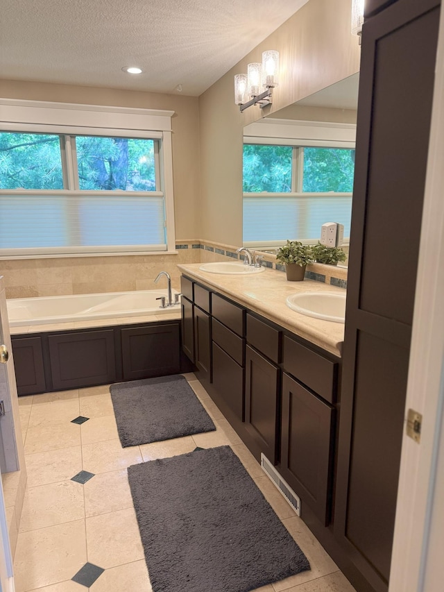 4312 France Ave S, Edina, MN 55410 - full bath with double vanity, a bath, a textured ceiling, a chandelier, and tile patterned flooring