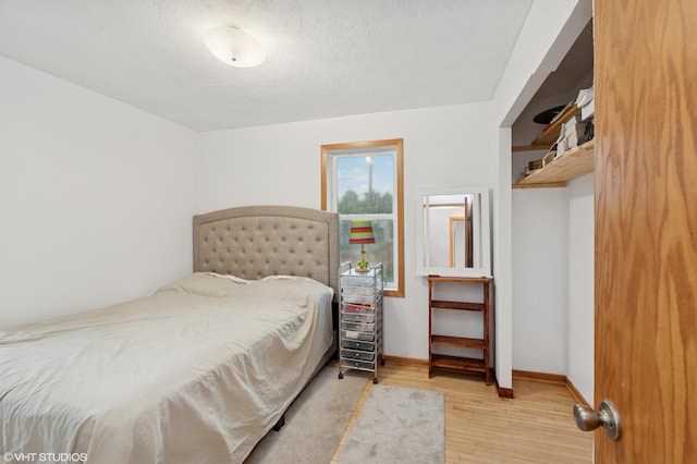 220 State St, Belle Plaine, MN 56011 - bedroom featuring wood finished floors, baseboards, and a textured ceiling