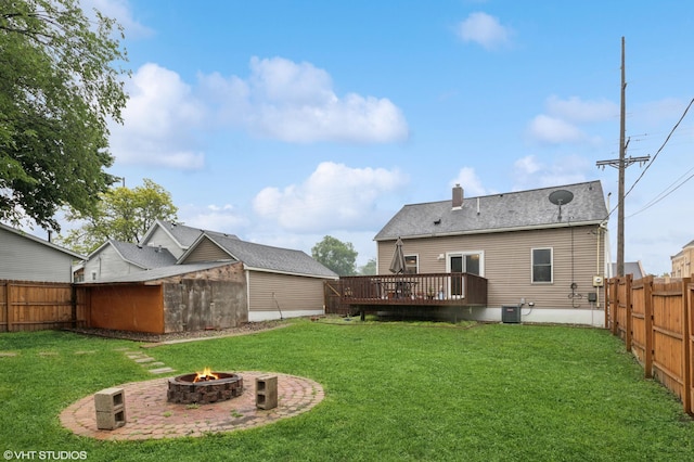 220 State St, Belle Plaine, MN 56011 - back of house featuring an outdoor fire pit, a wooden deck, central AC unit, a chimney, and an outbuilding