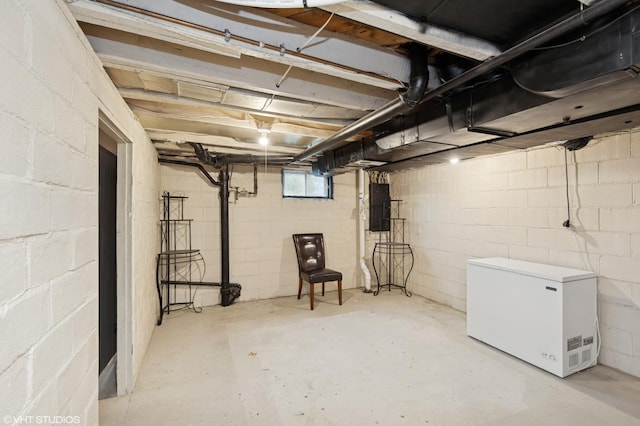 220 State St, Belle Plaine, MN 56011 - below grade area featuring refrigerator, electric panel, and concrete block wall