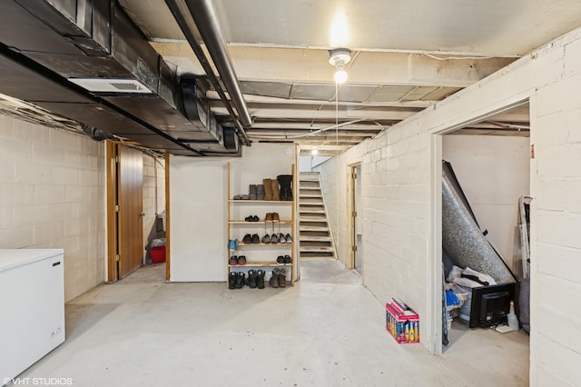 220 State St, Belle Plaine, MN 56011 - unfinished below grade area featuring fridge, concrete block wall, and stairway