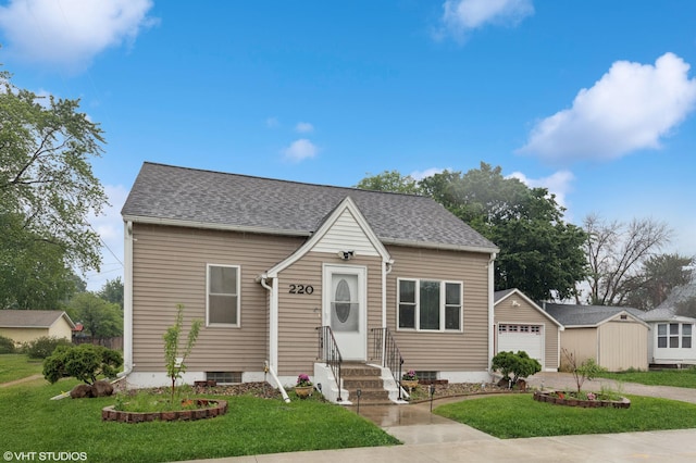 220 State St, Belle Plaine, MN 56011 - view of front of property with driveway, a front yard, an outdoor structure, roof with shingles, and a detached garage