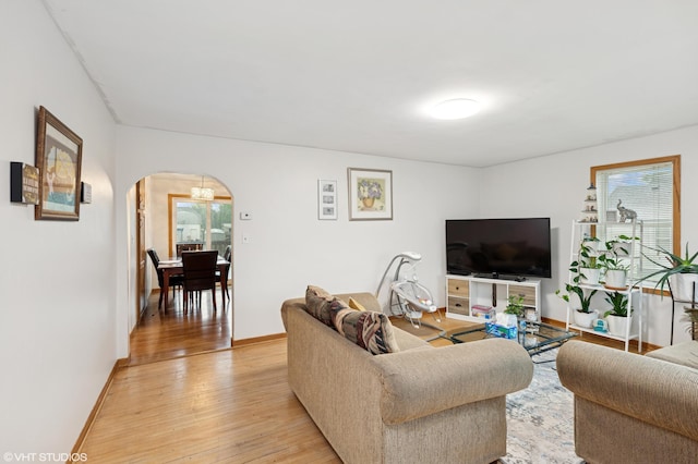 220 State St, Belle Plaine, MN 56011 - living room featuring arched walkways, light wood-style flooring, and baseboards