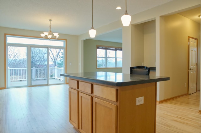 4629 Empress Way N, Hugo, MN 55038 - kitchen featuring light wood finished floors, dark countertops, a chandelier, a center island, and hanging light fixtures