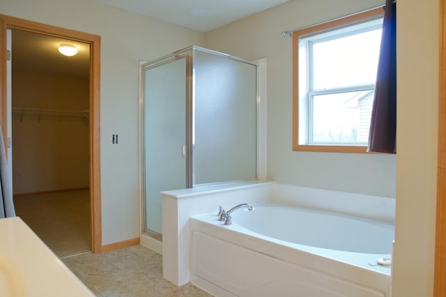 4629 Empress Way N, Hugo, MN 55038 - bathroom featuring a stall shower, a bath, a walk in closet, and baseboards